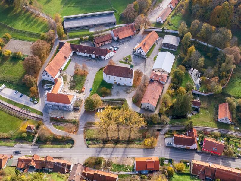 Luftbildaufnahme von Gomadingen-Offenhausen. Darauf zu sehen ist hauptsächlich der Gestütshof Offenhausen des Haupt- und Landgestüts Marbach und das Dominikanerinnenkloster Offenhausen.